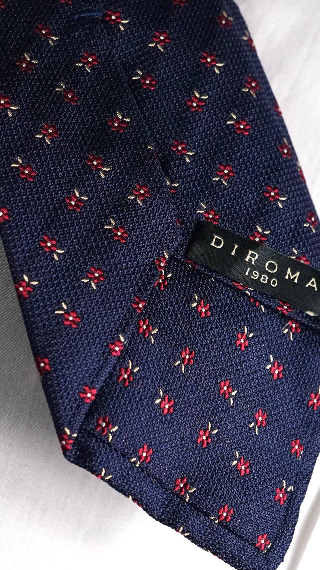 DIROMA 1980 label on the Ippolita navy floral jacquard silk tie